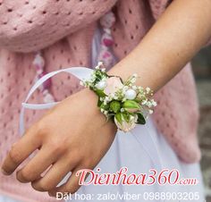 a close up of a person wearing a flower wrist corsage with flowers on it