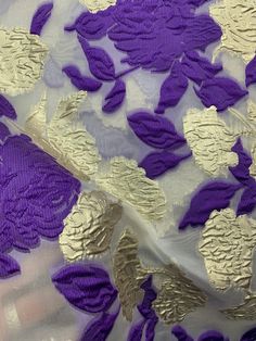 purple and gold fabric with flowers on it, as seen from the bottom down view