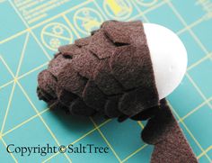 a close up of a stuffed animal on top of a cutting board next to scissors