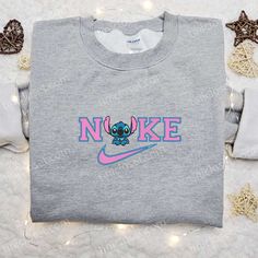 Introducing the Stitch x Nike Cartoon Embroidered Sweatshirt, a playful fusion of Disney magic and athletic style. This unique collaboration showcases the lovable Stitch character in vibrant embroidery, adding a touch of whimsy to your wardrobe. Crafted from premium materials, this sweatshirt offers ultimate comfort and durability. The relaxed fit and ribbed cuffs provide a [...] Fairy Aesthetic Outfit, Nike Cartoon, Disney Character Shirts, Stitch Merchandise, Nike Inspired, Lilo And Stitch Merchandise, Embroidered Apparel, Best Family Gifts, Maroon Hoodie