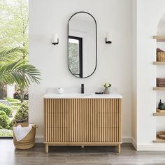 a bathroom with a wooden cabinet, mirror and shelves on the wall next to it