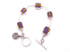 "Bellissimo This bracelet is a work of art. The furnace glass beads are created by hand and have  been combined with sterling silver components. The color combination is a purple, yellow, black with clear glass.  (see process below).  The dangling charm has two different sides, so you are able to choose which one you prefer. This bracelet is very simple and lovely.  If you need a different size that can be done.  Please message me. What is Furnace Glass Beads? Furnace Glass Beads are adapted fro Adjustable Glass Beaded Bracelets Nickel Free, Purple Glass Beaded Bracelets As Gift, Purple Glass Beaded Bracelets For Gift, Mother's Day Art, Glass Bracelets, Glass Bracelet, Minimalist Bracelet, Denver Co, Handmade Beads