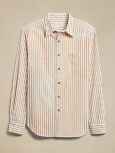 Classic in every way, this ultra-soft button-down shirt is crafted from sumptuous organic cotton, fashioned into a distinct ticking stripe fabric that adds luxurious texture to any adventure—a style well worthy of a revival.  ORGANIC: Made with cer Car Coat, Aviator Jackets, Aviator Style, Ticking Stripe, Gold Stripes, Leather Blazer, Striped Fabrics, Vintage Store, Casual Shirts For Men