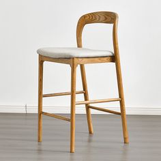 a wooden chair sitting on top of a hard wood floor next to a white wall