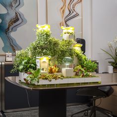 an office desk with plants and candles on it