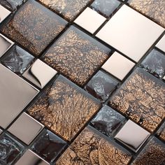 a close up view of a glass mosaic tile pattern with trees in the background and brown tones