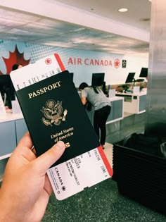 a person holding up a passport in an airport