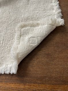 a close up of a white rug on a wooden floor with wood grained floors