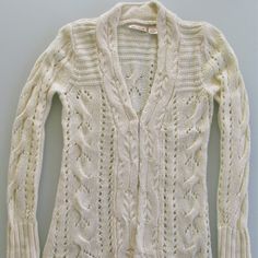 a white cardigan sweater hanging on a hanger