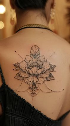 the back of a woman's shoulder with a flower tattoo on her left arm