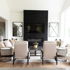 a living room filled with furniture and a flat screen tv mounted on the wall over a fireplace