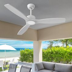 a ceiling fan that is on the outside of a house with an ocean view in the background