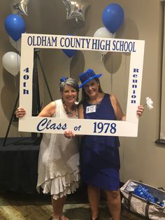 two women pose for a photo in front of a sign that reads class of'78