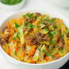 a close up of a bowl of food with meat and veggies in it