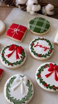 decorated christmas cookies on a table next to cotton floss and twine wreaths