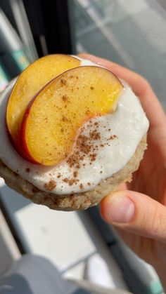 a person holding up a piece of food with some fruit on top of it in their hand