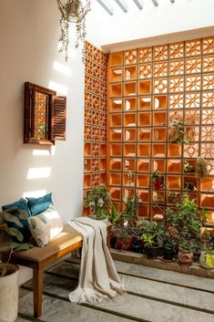 a wooden bench sitting under a window next to potted plants