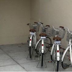 several bicycles are lined up in a row with baskets on the front and rear ends