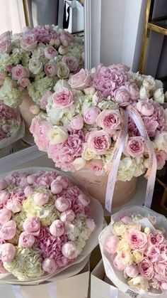 pink and white flowers are arranged in baskets