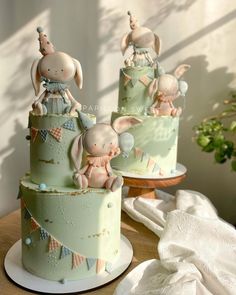 two cakes decorated with bunnies and rabbits on top of each other in pastel green frosting