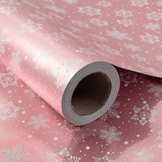 a pink and white snowflaked christmas wrapping paper with silver foil on it