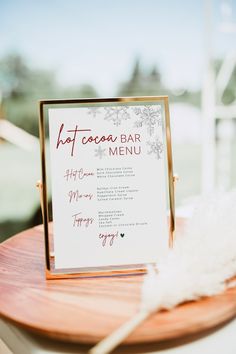 a sign that is sitting on top of a wooden table next to a white feather