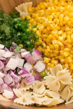 the ingredients for this dish include corn, red onions, and parsley in a wooden bowl