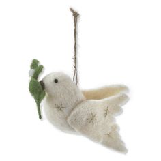 a white bird hanging from a string with a green toy in it's beak