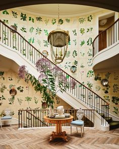 a room that has some flowers on the wall and a table in front of it