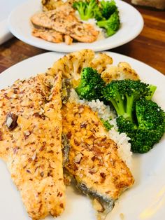 two white plates topped with fish and broccoli