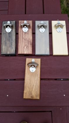 four different colors of door handles on a wooden bench