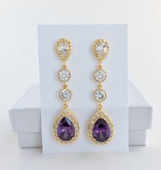 I've created these absolutely gorgeous super sparkly long purple amethyst crystal earrings in gold plated brass setting. Earrings feature a large teardrop with pear cut purple amethyst cubic zirconia center surrounded by tiny round zirconia crystals. Teardrop dangles from a bright cubic zirconia ear stud and two round cubic zirconia connectors. Total length of the earrings is 6 cms. For matching necklace click: For matching bracelet click: To browse my collection click : https://www.etsy.com/sho Luxury Purple, Purple Bridesmaid, Gold Bridal Necklace, Crystal Wedding Jewelry, Purple Bridesmaids, Gold Bridal Earrings, Amethyst Gold, Ear Stud, Matching Bracelet