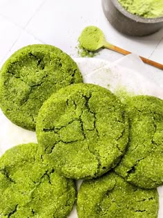 some green cookies are on a white table