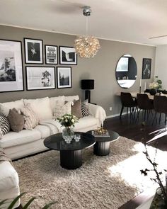 a living room filled with white furniture and pictures on the wall above it's coffee table