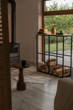 a living room filled with furniture next to a firewood log rack and a window