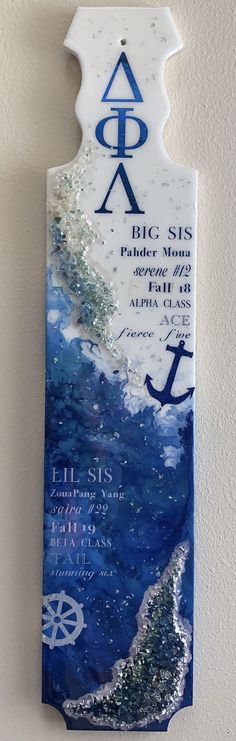 a blue and white plaque hanging on the side of a wall with an anchor in it