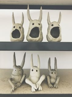 three sculptures of animals sitting on top of shelves