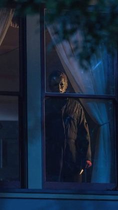 a scary looking person standing in front of a window