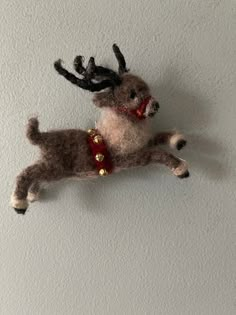 a stuffed reindeer hanging on the wall with its mouth open and antlers attached to it's back