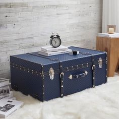 a blue suitcase sitting on top of a white fur covered floor next to a clock