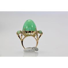 This is part of Chairish’s Fine Jewelry assortment.  18K Bullet Chalcedony and Jade 3 Stone Ring in Yellow Gold  This gorgeous 18K Bullet Chalcedony and Jade 3 Stone Ring in Yellow Gold is unique and you will not see another one. This ring is 19.31 high and deep and 17.67 round.  Furthermore, the Jade stones are approximately 0.75 carats each with a weight of 14.5 grams.  Bullet stones are very rare especially in this size. Do not wait. Elegant Green Opal Ring In 14k Gold, Luxury Oval Cabochon Emerald Ring With 17 Jewels, Luxury Emerald Ring With Oval Cabochon And 17 Jewels, Green Cabochon Jewelry For Evening, Luxury Oval Cabochon Emerald Ring, Elegant Green Opal Oval Ring, Green Oval Jewelry For Evening, Luxury Green Oval Gemstones, Luxury 14k Gold Opal Ring