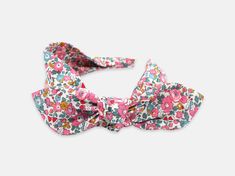 Designed for comfort and ease of wear, this women's side bow headband is the perfect way to add the finishing touch to your outfit. This playful design features a detachable bow, allowing you to create different looks with your headband. Handmade using the softest Liberty London Tana Lawn cotton, this headband is kind to the hair and protects from any tension breakage. Liberty London Betsy Ann E pink print 100% Liberty London Tana Lawn cotton Detachable bow and wide fabric base Flexible recyclab Adjustable Decorative Bow Hair Accessory For Summer, Adjustable Hair Accessories With Decorative Bow For Spring, Adjustable Hair Accessories With Decorative Bow For Summer, White Headband With Bow Tie, White Bow Tie Headband, White Bow Tie Hair Accessories For Summer, Spring Bow Headband Hair Accessories, Summer Bow Headband, Adjustable Pink Bow Headband