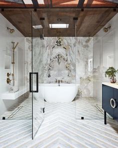 a bathroom with marble walls and flooring in the middle, along with a bathtub