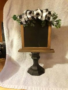 a small chalkboard on top of a pedestal