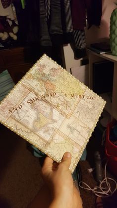 a person holding up a map with words on it in front of some other items