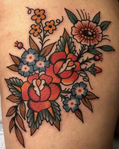 a woman's thigh with flowers and leaves on it