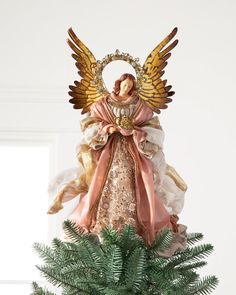 an angel statue sitting on top of a potted plant