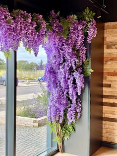 purple flowers hanging from the side of a building