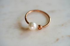 Bridal jewelry ~ Bridesmaid jewelry ~ Classic pearl ring. Beautiful pearl ring with double prong detail in 14k rose gold plating and imitation pearl accent. Dainty, feminine and classic - this ring is a perfect gift for bridesmaids, bridal showers, and birthdays! Adjustable one size up or down. Add gift wrap for $3.00 at checkout! Your present will be in a jewelry box wrapped in colorful patterned paper with glitter pom poms! It comes nicely wrapped in tissue paper, sealed with a sticker, and re Minimalist Rose Gold Pearl Ring, Minimalist Rose Gold Pearl Wedding Ring, Ring Layering, Pearl Stacking Ring, Ring Minimal, Jewelry Classic, Prong Ring, Rose Gold Pearl, Layered Rings