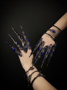 a woman's hand with blue and black nail art designs on it, holding onto her arm